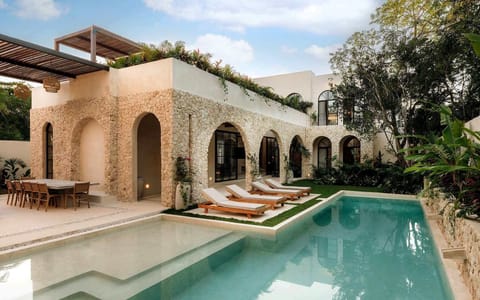 A private pool framed by arches and lush tropical greenery.