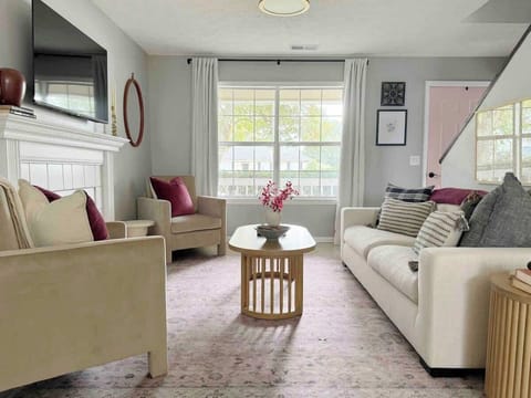 Warm accents and modern furniture make this room as stylish as it is comfortable, complete with abundant natural lighting pooling in from the front and back of the house. 