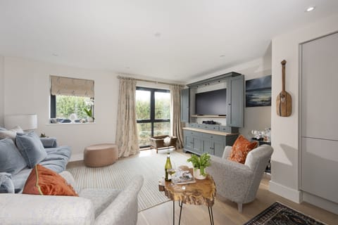 Open plan living  space with a Tv and seating for all guests - Harlyn Folly