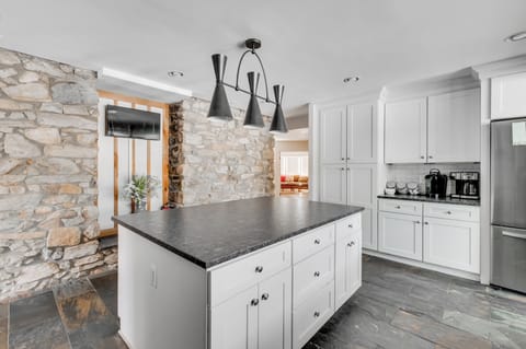 Kitchen: Cook up a feast in this stylish space with sleek counters and charming stone accents!