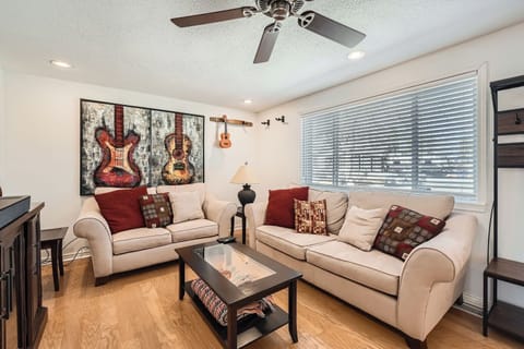 Settle into your cozy living room with plush sofas and musical art adorning the walls, creating the perfect space to unwind.