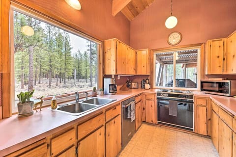 Fully equipped kitchen with breakfast bar and views of the pine forest—cook meals together with ease.