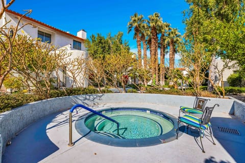 Resort-style heated spa surrounded by palms and desert landscaping