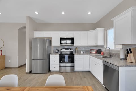 Clean, bright full kitchen for making meals at home.