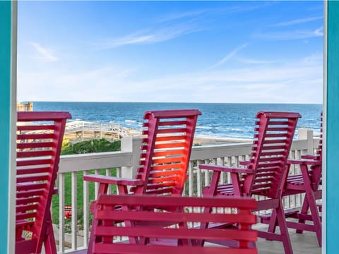Relax on the furnished beachfront deck with colorful Adirondack seating and wide Gulf of Mexico views—an inviting outdoor space for morning coffee, ocean breezes and coastal sunsets.