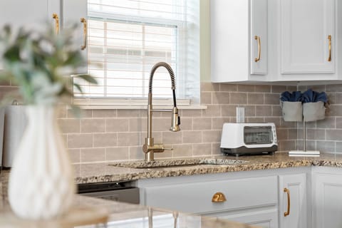 - Sparkling granite countertops paired with elegant gold fixtures elevate your kitchen experience
- Includes a modern pull down sprayer faucet for added convenience
- Fully stocked with essentials and everyday comforts for your stay