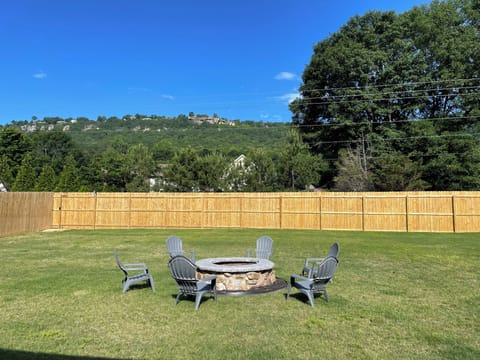 Backyard with 8 ft enclosed privacy fence with wood burning fire pit.