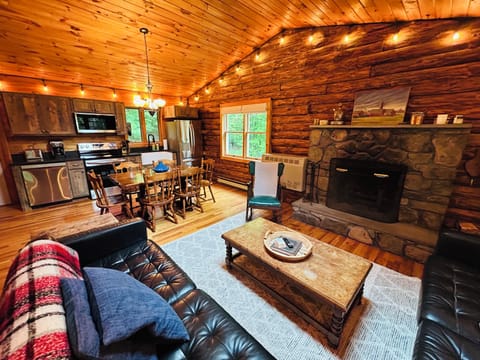 Interior living room with open floor plan, stone fireplace and remodeled kitchen