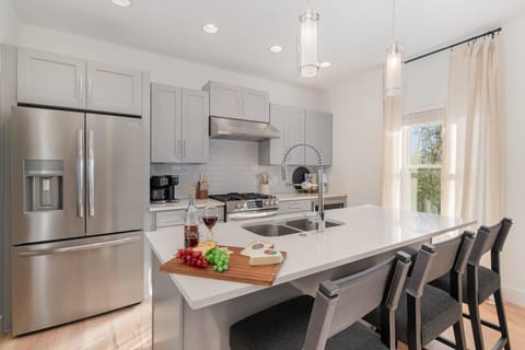 A sleek, modern kitchen equipped with everything you need to cook and gather, featuring contemporary appliances and ample counter space.