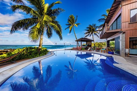 Relax beside the oceanfront saltwater infinity pool, where swaying palms, panoramic Pacific views, and unforgettable North Shore sunsets create a true island oasis.