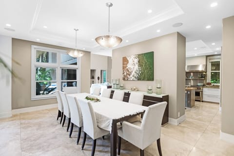 Formal dining for ten with soft lighting and views of the lush grounds.