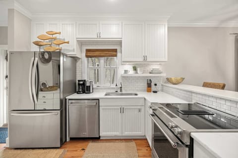 Kitchen: Stainless steel appliances, drip coffee maker, cooking utensils, tableware