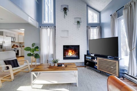 Spacious Living Room with Vaulted Ceiling, Large Smart TV, and Decorative Fireplace- Flooded with Natural Light!