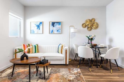 A stylish living-and-dining space seamlessly united by light tones and symmetry, inviting both relaxation and conversation.