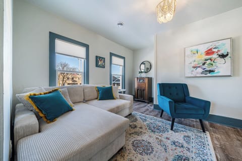 - Bright living area with cozy sectional and teal accent chair for relaxing afternoons   - Modern décor, colorful art, and streaming-ready TV create a stylish lounge vibe   - Natural light and warm tones make this living space your perfect comfort corner