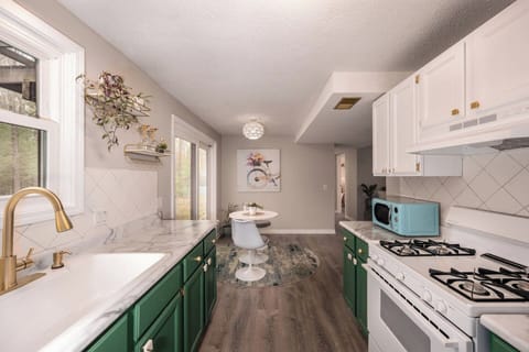 The Kale Green cabinets bring the colors of the wooded backyard inside.