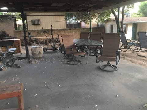 Relaxing covered area with firepit, work out equipment, and rocking chairs