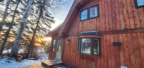 Entry door, kitchen window and 2 guest bedrooms above. Inlet view behind trees
