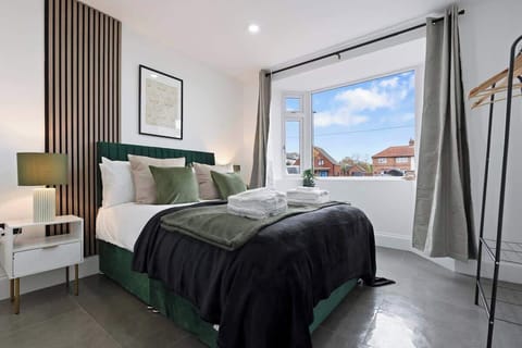 A bedroom with a double bed and a window  
