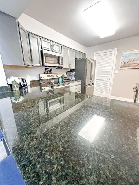 Fully equipped kitchen with granite countertops and updated cabinetry, perfect for preparing meals during your stay.