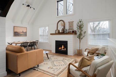 Gather around the fireplace in this airy, light-filled living space—styled with natural tones, soft textures, and room to connect.