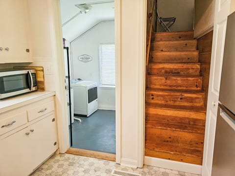 Stairway up to the twin bedroom from the kitchen and a view into the laundry rm.