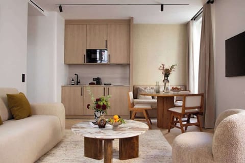 Une belle pièce à vivre dotée d'un canapé convertible, une table d'appoint, une table à manger et une TV. Cuisine ouverte sur la pièce à vivre 