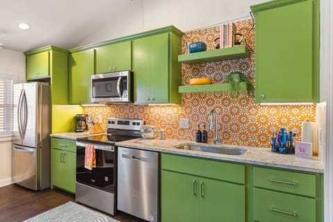 Fully equipped kitchen with all your cooking essentials, drip coffee maker + coffee. Dining table with seating for 2. This room opens up into the living room. Bold colors, bright lights and decor all throughout the condo.