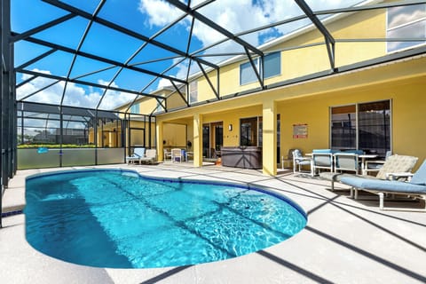 beautiful pool deck with a covered lanai, perfect for outdoor dining and relaxation. Unwind in the hot tub for the ultimate vacation experience