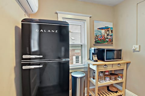 Kitchenette with fridge, microwave, sink, coffee station. No stove