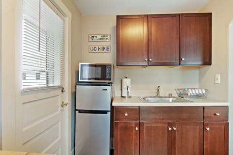 Sink, mini-fridge, and microwave in kitchenette. No stove