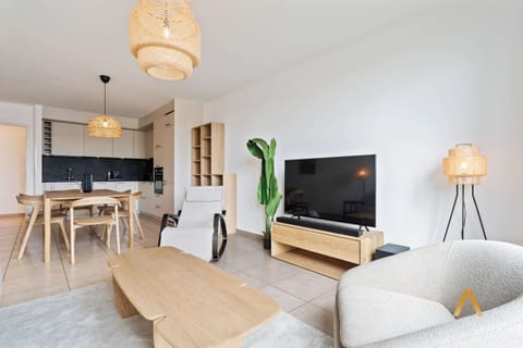 Open-concept living and dining area with contemporary furnishings. Enjoy your favorite shows on the flat-screen TV or unwind with a book in this inviting space.