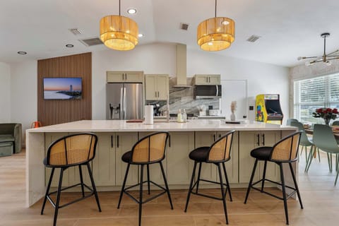 A close-up view of elegant bar stools with rattan backs, perfectly complementing the modern kitchen island. The sleek design combines comfort and style, inviting guests to enjoy casual meals or morning coffee in a chic, welcoming atmosphere.
