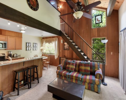 Living room with Smart TV, wood burning fireplace, and balcony access