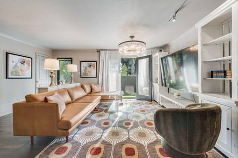 French doors open to the outdoor patio, living room with a roomy leather sectional and plenty of seating, plus a large Smart TV for ultimate relaxation and entertainment. 