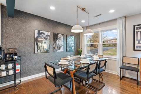 Dining area with glass table, bold wall & art featuring Dolly, Cash & Hendrix.