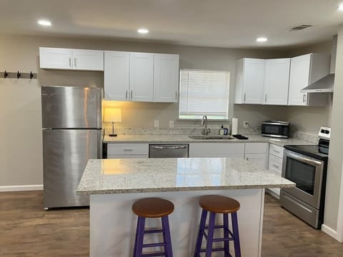 Modern kitchen with a large island and bar seating, ideal for gathering and enjoying meals during your stay in Stephenville