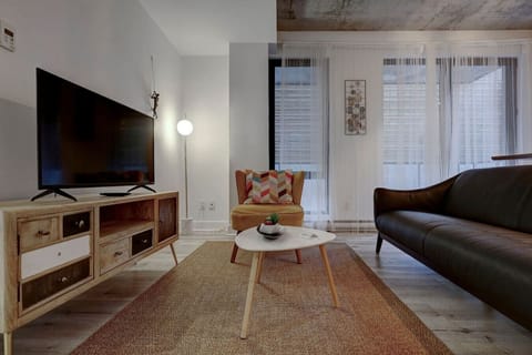 Stylish and cozy living room featuring a sleek TV setup, warm lighting, and a comfortable leather sofa for ultimate relaxation.