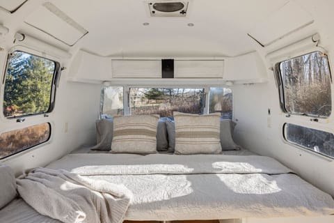 Cozy queen bed and bunk beds at the Airstream.