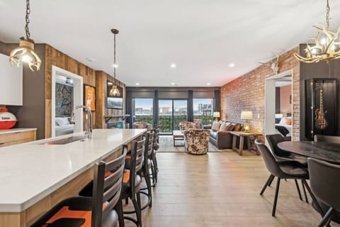 Spacious open-concept layout with kitchen + island seating, dining area, and a cozy living room—perfect for groups to spread out, hang together, and enjoy Nashville vibes with patio access right outside.