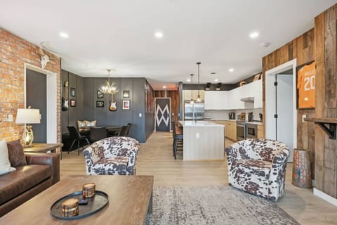 Spacious living room with a queen sleeper sofa, tons of seating, and easy access to the wraparound patio. Open-concept layout flows right into the kitchen + dining area—perfect for groups to hang, snack, and pregame Nashville-style.