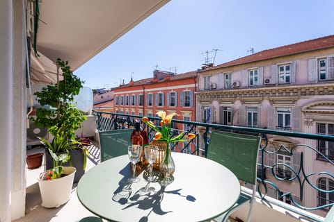 This charming balcony offers lovely views of colorful facades and creates a welcoming atmosphere for relaxation.