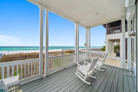 Sway in your rocking chair while turquoise waves dance before you on this covered porch—your perfect perch for morning coffee and endless ocean views.