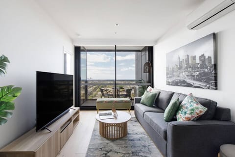 Sink into the air-conditioned living room, where a cozy two-seater sofa, TV and city views set the scene for a laid-back afternoon.