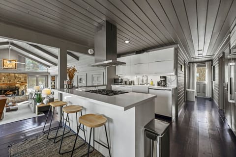Bright and functional kitchen layout featuring a breakfast bar with stool seating for three and open sight lines to the living area.