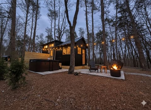 Soak under the stars in your personal hot tub, warm up by the fire with cozy Adirondack seating, and grill dinner surrounded by towering pines—your perfect woodland retreat awaits.