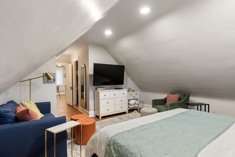 Stylish attic bedroom combining restful comfort and flat screen TV.
