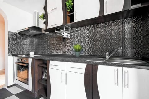 Cook with ease in the fully equipped kitchen, featuring modern appliances and sleek design.