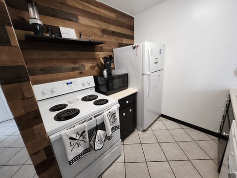 Full kitchen with stove top, oven, microwave, and full-size fridge 