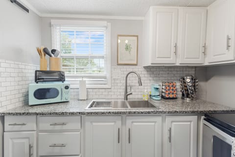  Cook with ease in this modern kitchen featuring stainless steel appliances, granite countertops, and all the essentials for your stay.